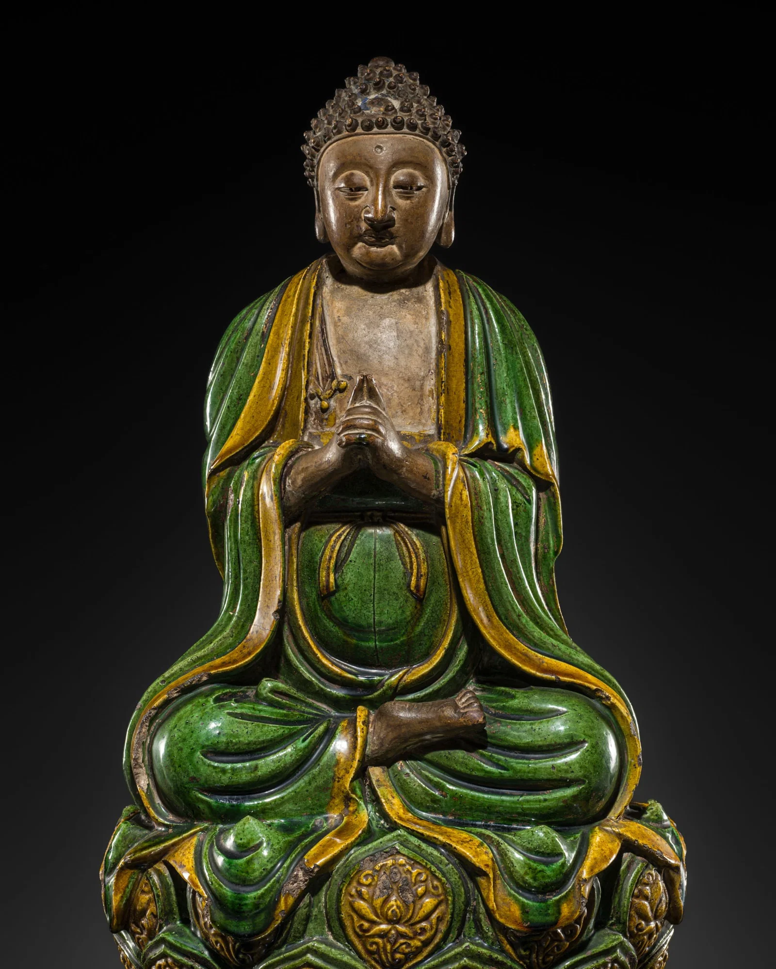 AN EMERALD GREEN AND AMBER GLAZED FIGURE OF BUDDHA VAIROCANA, MING DYNASTY