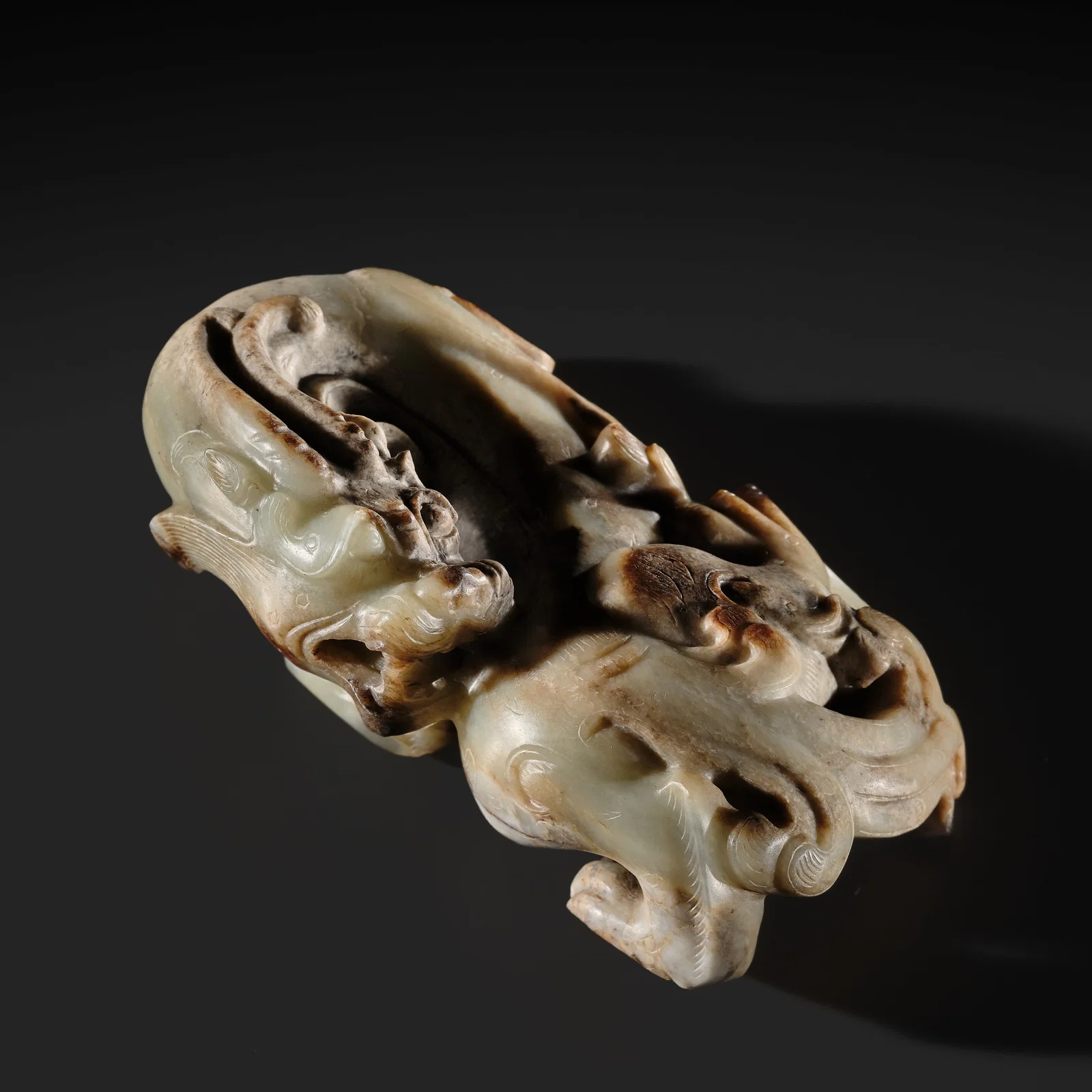 AN EXCEPTIONAL AND POWERFULLY CARVED WHITE AND BROWN JADE CARVING OF A BIXIE, WESTERN HAN DYNASTY