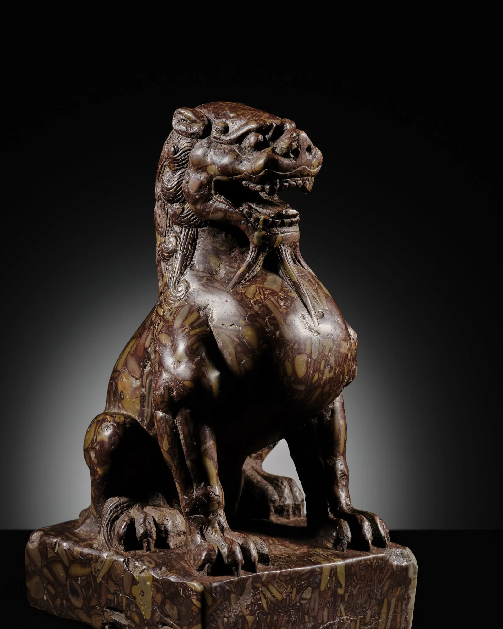 AN EXCEPTIONAL PUDDINGSTONE FIGURE OF A LION, TANG DYNASTY