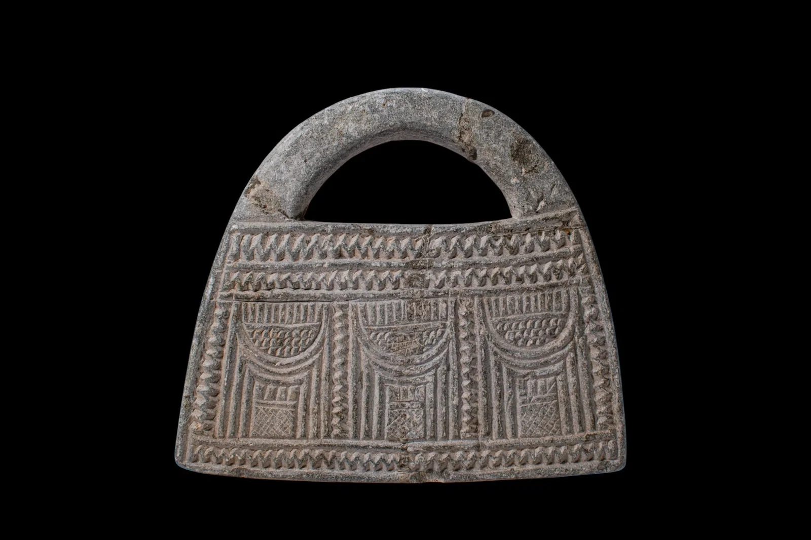 BACTRIAN SCHIST 'HANDBAG' WEIGHT WITH ARCHITECTURAL DECORATION