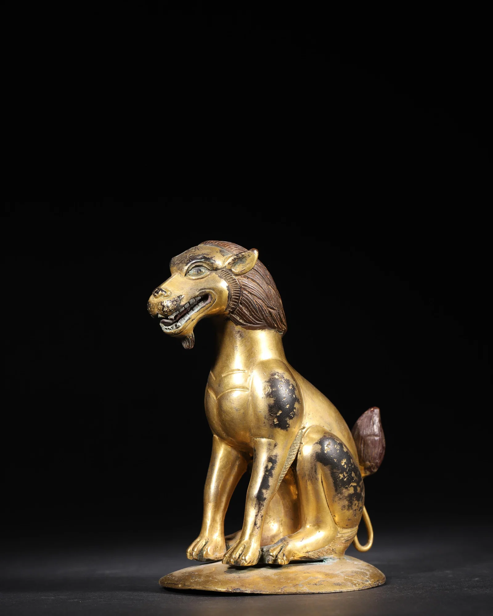 MING DYNASTY GILT-BRONZE SEATED AUSPICIOUS BEAST STATUE