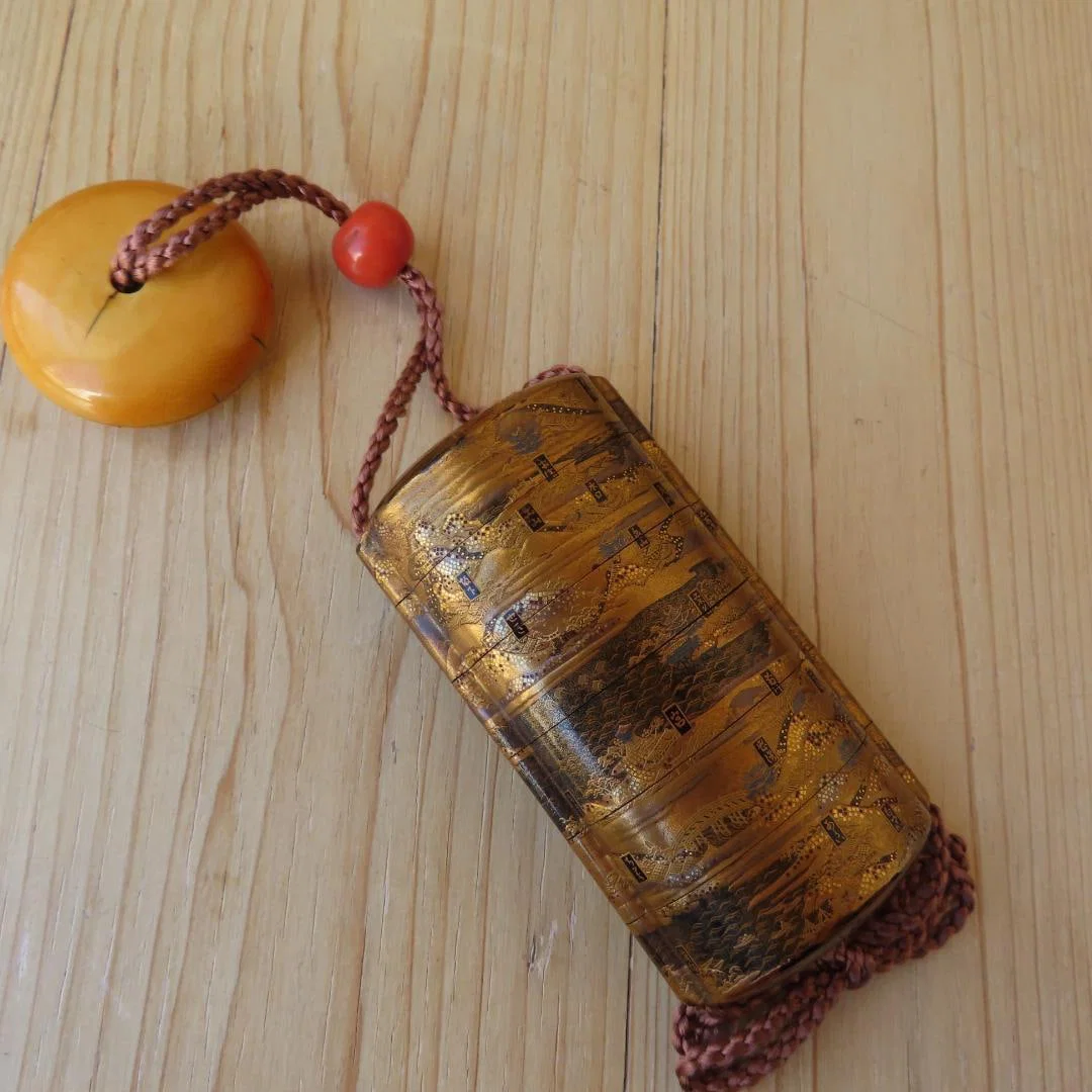 Museum-quality exhibit: A gold lacquer inrO (small container) and netsuke (miniature carving) from