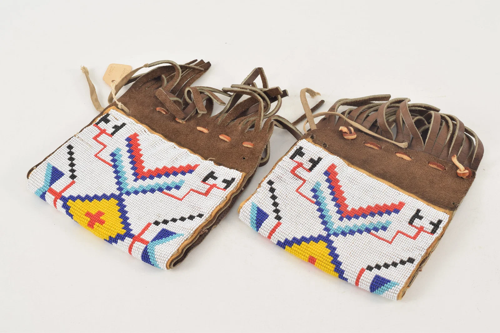 Pair of Pawnee American Indian beaded hide fringed cuffs. Label attributing Terry Running Deer/Ted