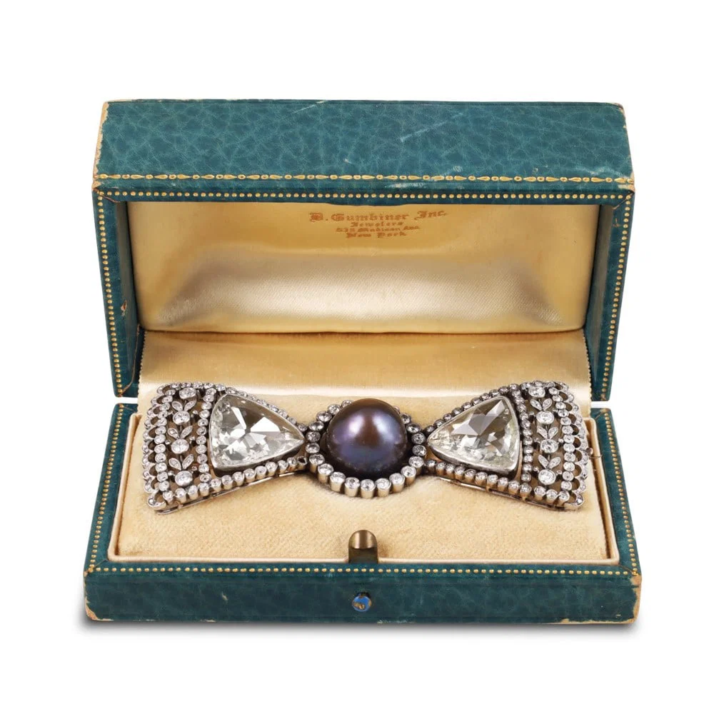 PLATINUM BOW-SHAPED BROOCH SET WITH A NATURAL SALTWATER PEARL AND DIAMONDS