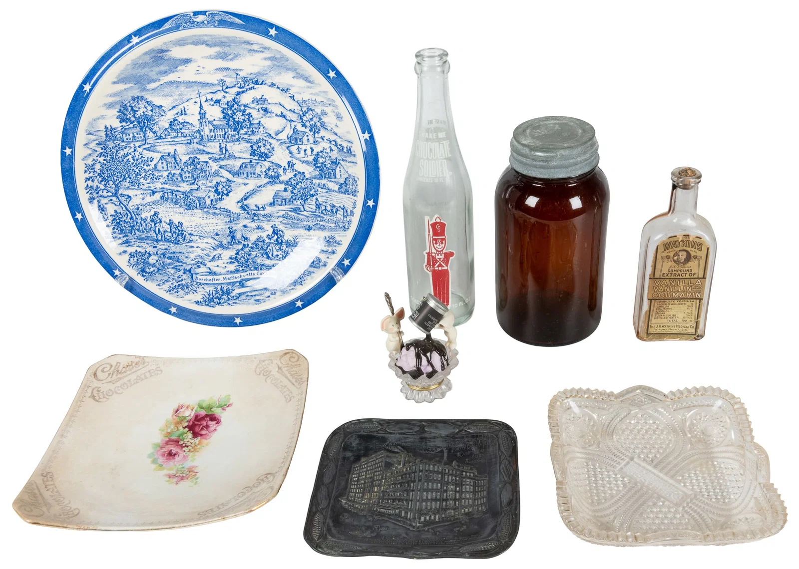 Seven chocolate and cocoa advertising bottles, trays, and plates.