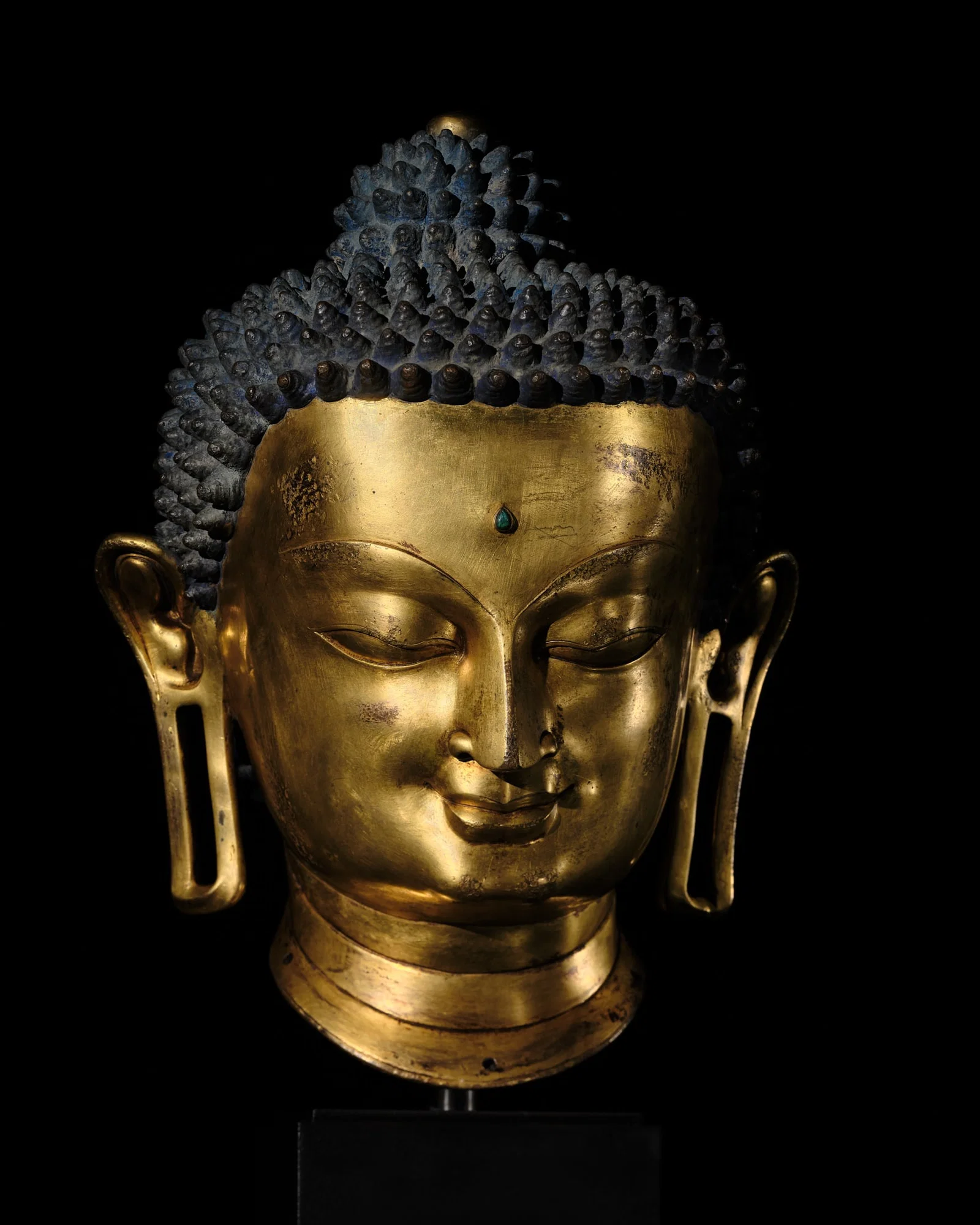 THE MONUMENTAL AND UNIQUE 'ULRICH VON SCHROEDER' GILT-COPPER HEAD OF BUDDHA, TIBET, 14TH CENTURY