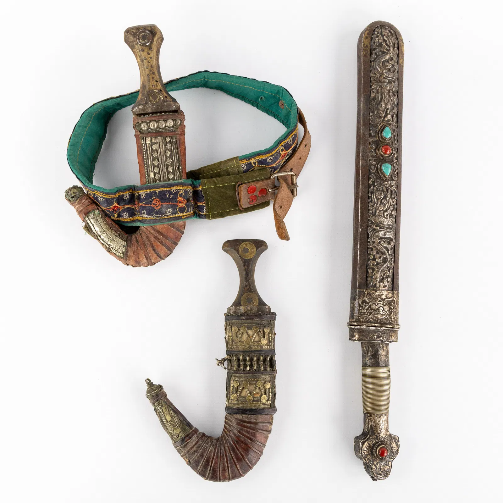 Two Yemeni Jambiya daggers and a Tibetan sword with silver repousse decorations.